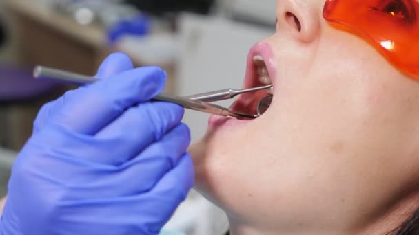 Jeune femme en examen préventif en chaise dentaire chez le dentiste. Concept de soins des dents . — Video