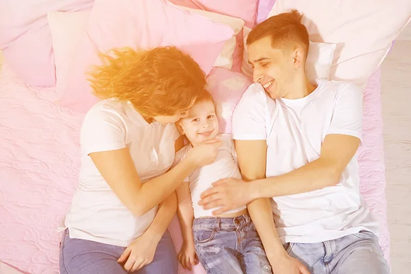 Szczęśliwy rodzina w łóżko, Mamo, syn i tata są całowanie i przytulanie razem. — Zdjęcie stockowe