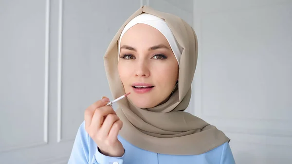 Donna musulmana sta applicando polvere compatta guardando specchio . — Foto Stock