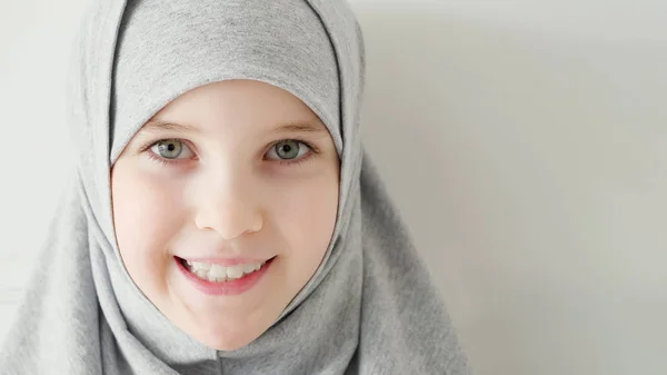 Ung muslimsk tonårs flicka i hijab blygt tittar på kamera och leende. — Stockfoto