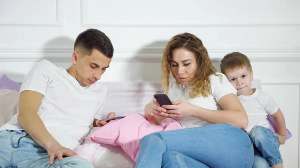 Parents are looking in their mobile phones not paying attention to their child. Escape of reality, dependence from gadgets.