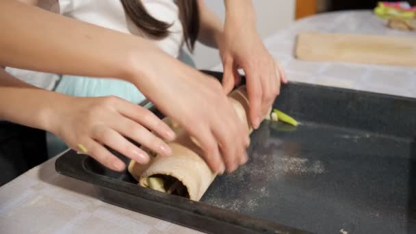 Mamá y su hija adolescente están cocinando apfelstrudel en la cocina en la bandeja para hornear — Vídeo de stock