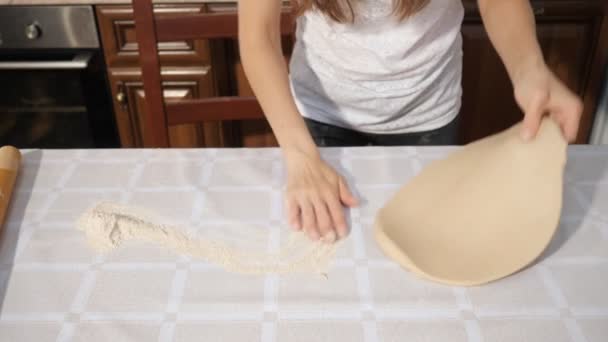 Mulher está rolando massa na mesa da cozinha, mãos fechadas . — Vídeo de Stock