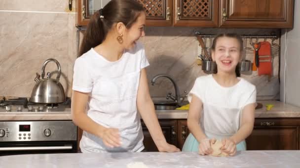 Brincalhão mãe e adolescente menina está cozinhando juntos na cozinha manchando uns aos outros na farinha . — Vídeo de Stock