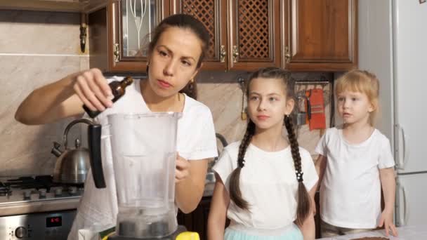 Η μαμά είναι μαγείρεμα κρέμα χρησιμοποιώντας μπλέντερ με τις κόρες της στην κουζίνα. — Αρχείο Βίντεο