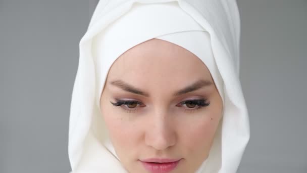 Başörtüsü takan çekici Müslüman kadın kameraya bakıyor ve gülümsüyor. — Stok video