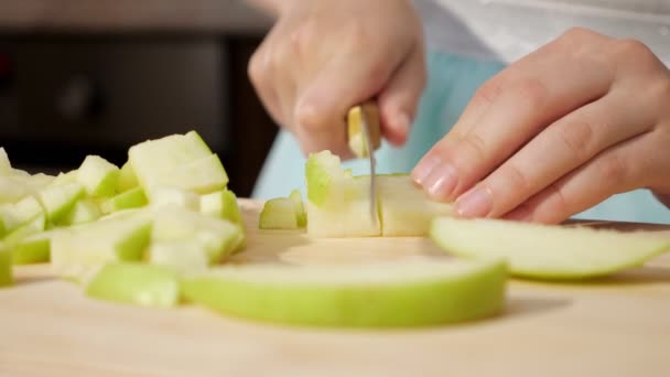 Teen ragazza sta lentamente tagliando mela su piccoli pezzi, mani primo piano . — Video Stock