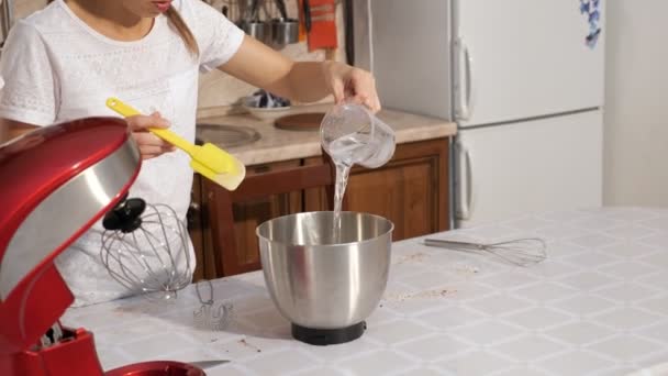 Woman is pouring syrup in mixer bowl to cook cream for cake. — Stock Video