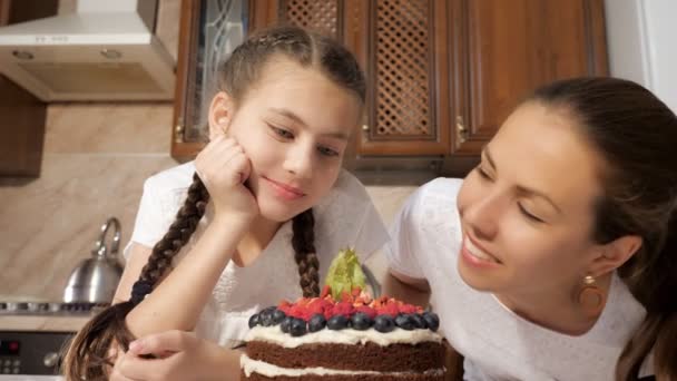 Feliz mãe e filha estão cheirando bolo de chocolate cozido com bagas . — Vídeo de Stock