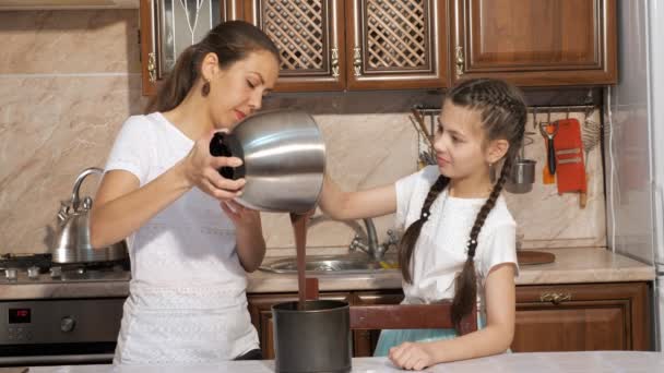Mamma e figlia stanno cucinando un pan di Spagna insieme in cucina a casa . — Video Stock