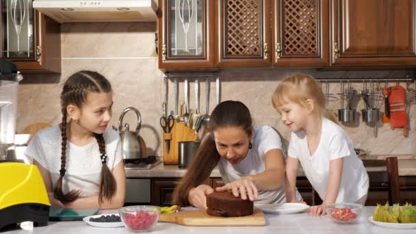 Ευτυχισμένοι οικογένεια μαμά και κόρες μαγειρεύουν μαζί τούρτα γενεθλίων. — Αρχείο Βίντεο