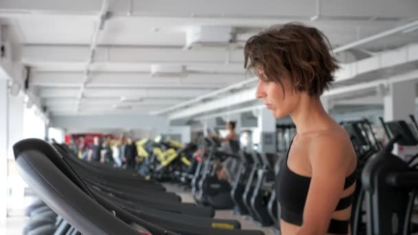 Starsza kobieta jest szkolenie na bieżni w siłowni. Fitness, koncepcja sportu. — Wideo stockowe