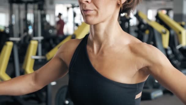 Sportowa Kobieta w odzieży sportowej rozprzestrzenia ręce na bok z hantlami w siłowni. — Wideo stockowe