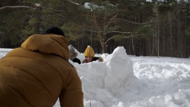 Mama, Sohn und Papa spielen Schneeballschlacht im Winterwald. Familienwochenende. — Stockvideo