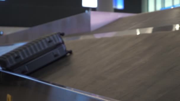 Grijze koffer op bagagetransport band in de luchthaven terminal. — Stockvideo