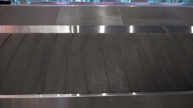 Havaalanı terminalinde bagaj konveyör bandı, yakın çekim görünümü.