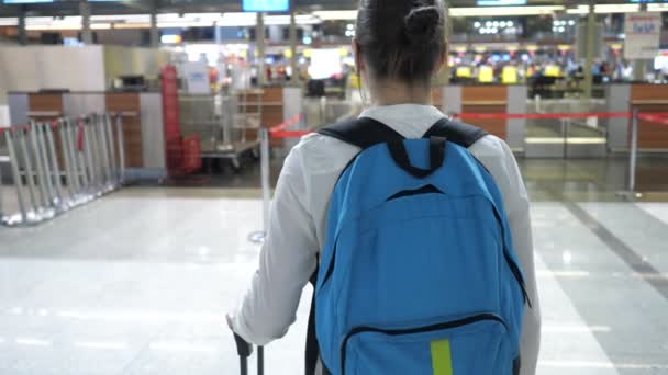 Mujer va a la recepción de registro en la terminal del aeropuerto, vista trasera . — Vídeos de Stock