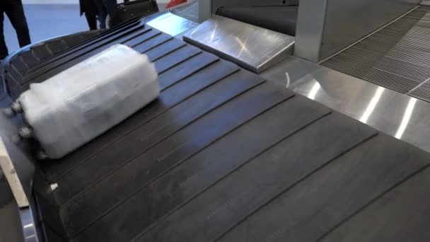 Maleta se está moviendo en la cinta transportadora de equipaje en la terminal del aeropuerto — Vídeos de Stock