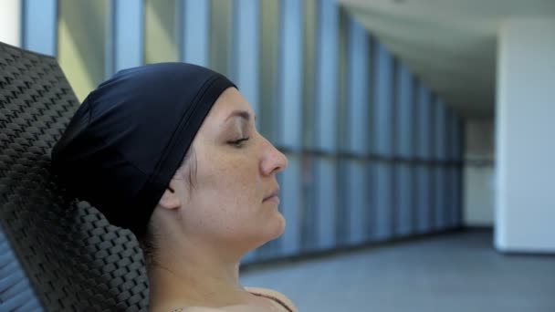 Femme en casquette se repose sur un transat après la piscine . — Video