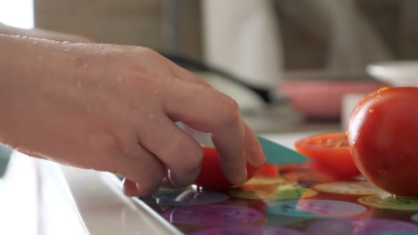 Mulher está cortando tomates para salada mãos molhadas, mãos close-up . — Vídeo de Stock