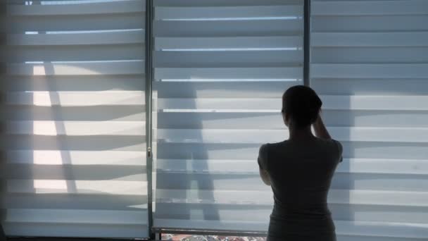 Mujer está abriendo persianas, mirando a la ventana con vista panorámica de la ciudad y estiramiento . — Vídeo de stock