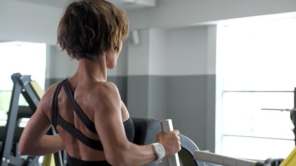 Mujer deportiva está haciendo ejercicios para los músculos de la columna vertebral en simulador de bloqueo — Vídeo de stock