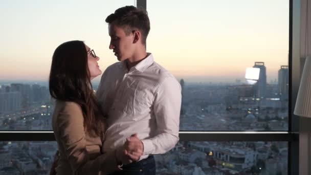 Pasangan, pria dan wanita menari di dekat jendela panorama dengan pemandangan kota . — Stok Video