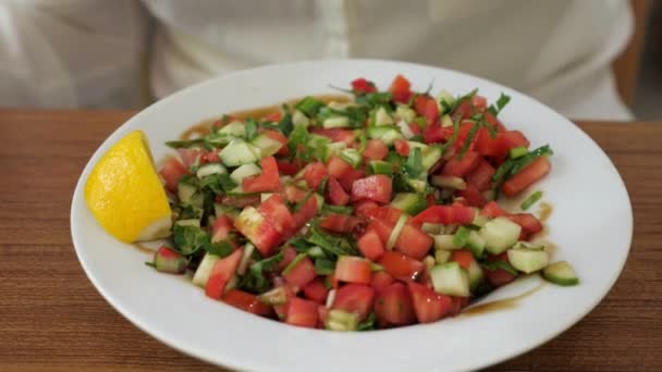 Mujer está comiendo ensalada de verduras con limón y verduras, plato de primer plano . — Vídeos de Stock