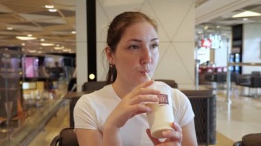 Bakü, Azerbaycan, 23-05-2019: Mcdonalds'ta kadın samandan milkshake içiyor.