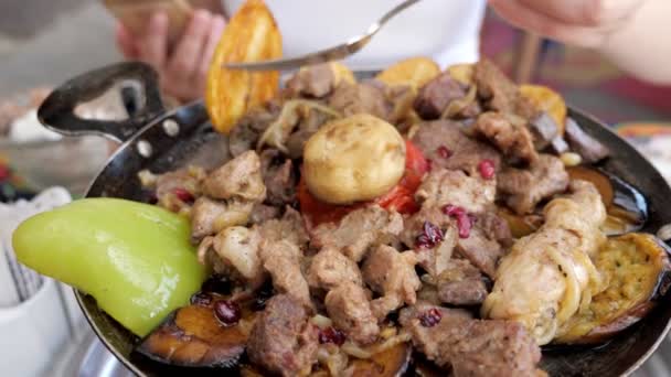 Mujer comiendo carne con verduras servidas en sartén en restaurante, primer plano . — Vídeos de Stock