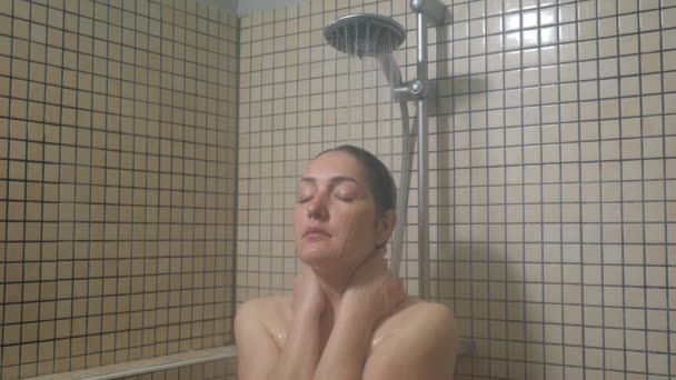 Portrait of young woman taking a warm shower enjoying process with close eyes. — Stock Video