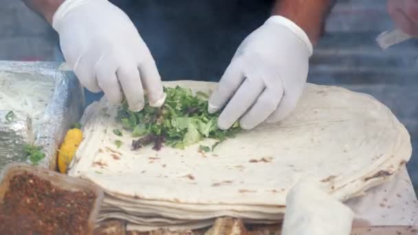 Man is cooking making ekmek with fish at street market, hands in gloves closeup. — Stock Video