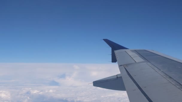 Voler sur l'avion au-dessus de la surface des nuages, vue de la fenêtre sur l'aile . — Video