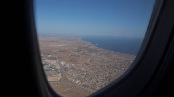 Vista de la ciudad desde la ventana del jet de pasajeros — Vídeo de stock