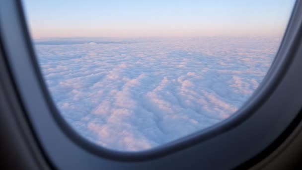 Atemberaubende Aufnahmen von Luftaufnahmen über Wolken aus dem Flugzeugfenster. — Stockvideo