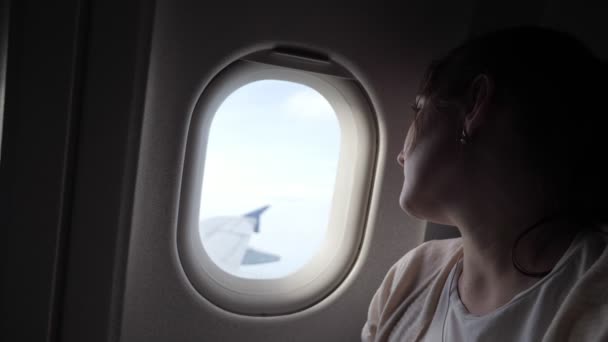 眠い疲れた女性の肖像画は、飛行機の窓のディルン飛行を見ています. — ストック動画