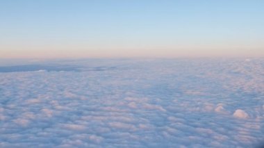 Pembe ve mavi bulutların üzerinde uçmak güzel gün batımında kar gibi görünüyor.