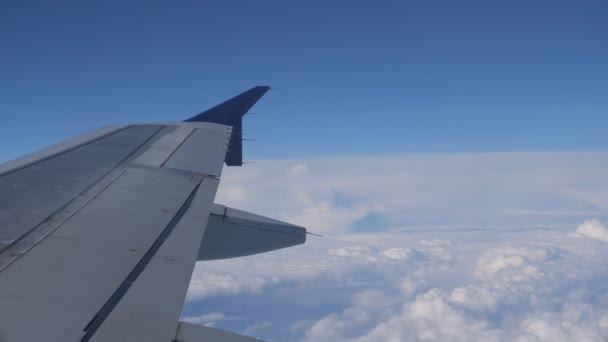 Voler sur l'avion au-dessus de la surface des nuages, vue de la fenêtre sur l'aile . — Video