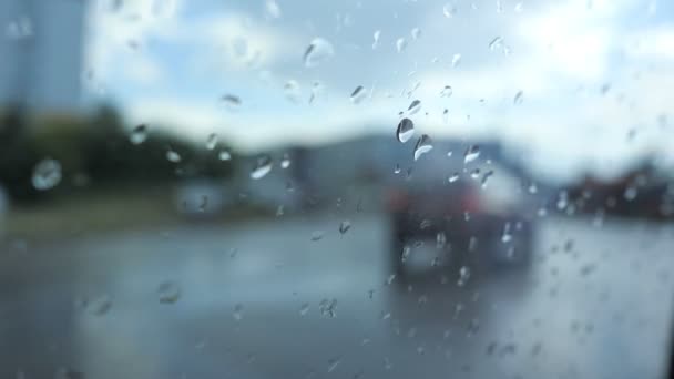 Closeup raindrops on car window, view on road with cars through it. — Stock Video