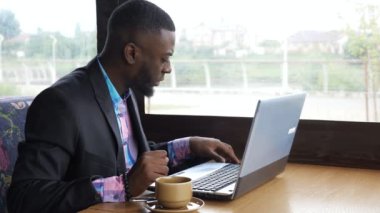 Siyah işadamı Cafe ve içecekler kahve akıllı telefon ile Laptop çalışır.