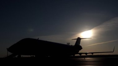 Yatılı için akşam pistte uçağa binen kadın turist silueti.