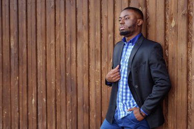 Takım elbiseli Afro Amerikan adam kendinden emin ve uzağa bakıyor.