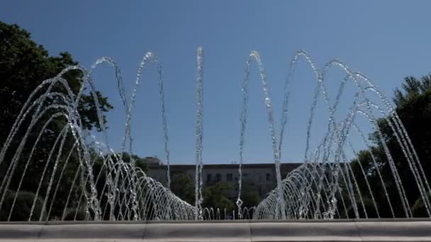 Σιντριβάνι με πίδακες νερού που πέφτουν στο κέντρο του πάρκου την καλοκαιρινή μέρα. — Αρχείο Βίντεο