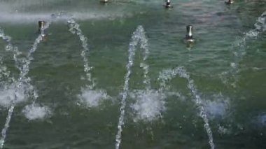 Şehir parkında Çeşme içinde mavi seramik adımlarla su akar.