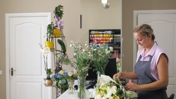 Vrouw bloemist sellor geeft bloem boeket aan man klant in bloemschikken winkel. — Stockvideo