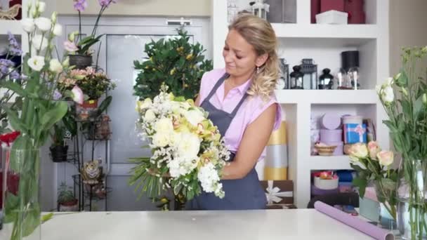 Γυναίκα επαγγελματίας ανθοπώλης κάνει τεράστια ανθοδέσμη λουλουδιών στο φλοϊνιστικό στούντιο. — Αρχείο Βίντεο