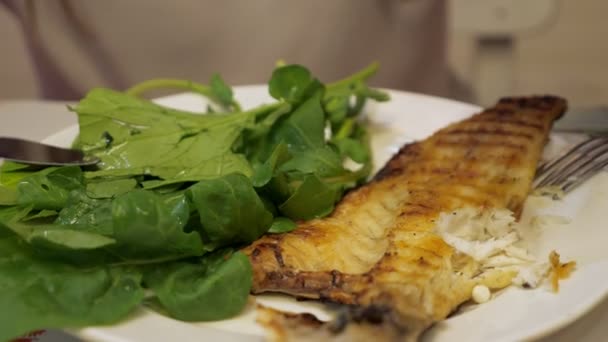 Unrecognizable woman is pouring fish with lemon juice, squeezing a slice of lemon — Stock Video