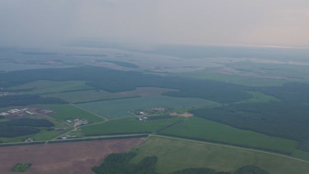 Aerial view at coastal town, fields and sea in mist from the plane window. — Stock Video