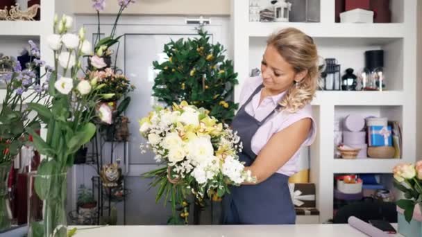 Woman professional florist makes huge flower bouquet in floristic studio. — Stock Video