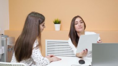 kız resepsiyonist ziyaretçi konuşurken form kağıt tutar
